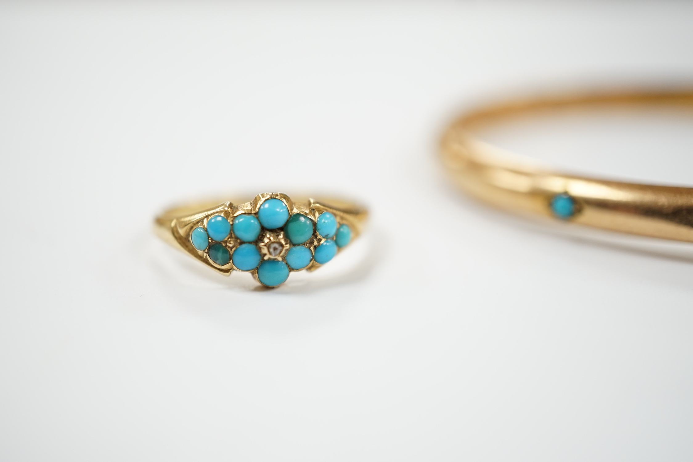 A Victorian yellow metal and three stone cabochon turquoise set hinged bangle, together with a similar yellow metal turquoise and diamond chip cluster set ring, gross weight 10.9 grams.